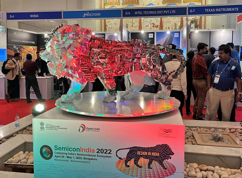 Visitors stand next to a 'Make In India' logo during a three-day semiconductor event in Bengaluru in April 2022. Reuters