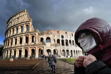 A man wearing a protective mask passes by the Colosseum in Rome on March 7 amid fear of Covid-19 epidemic. AFP 