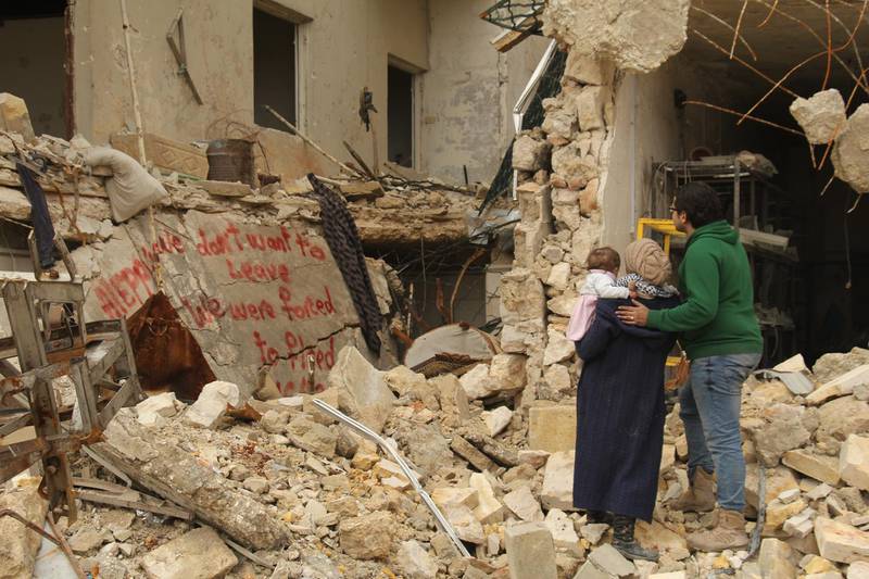 Waad Al-Kateab, her husband, Hamza and their daughter, Sama, review the words they painted on a bombed-out building. Courtesy Waad al-Kateab