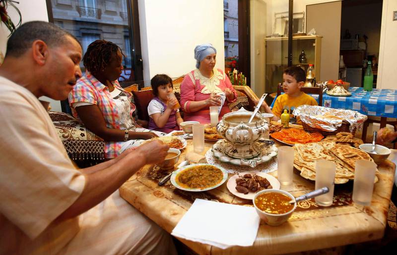 A family breaks the day's fast with the Iftar meal on the first day of the Muslim fasting month of Ramadan in Paris July 10, 2013. Muslims in France began their observance of this month of abstinence on Wednesday. REUTERS/Youssef Boudlal    (FRANCE - Tags: RELIGION FOOD) *** Local Caption ***  PARi5_FRANCE-_0710_11.JPG