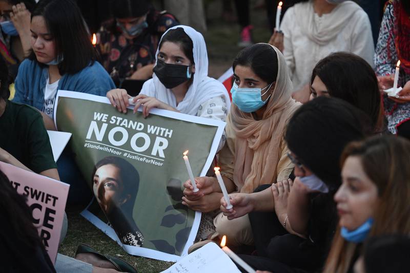 Women rights activists hold placards and candles during a protest rally against the brutal killing of Noor Mukadam, the daughter of a former Pakistani diplomat who was found murdered at a house in Pakistan's capital. AFP