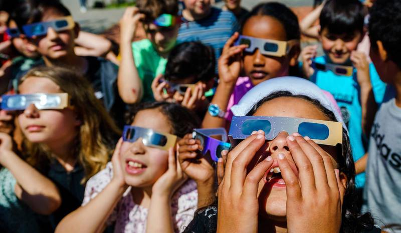 Pupils at IBS Ababil primary school look at a solar eclipse with special glasses, in Schiedam, the Netherlands. This was the first partial solar eclipse since 2015, with the sun partly obscured by the moon.  EPA