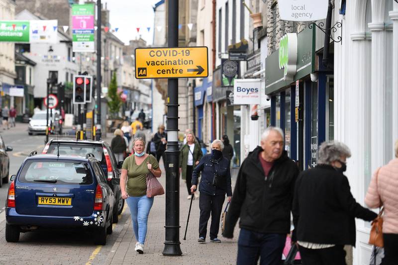 Members of the public walk past shops in Kendal in Cumbria, where surge testing has been deployed following an outbreak of a coronavirus variant of concern. AFP