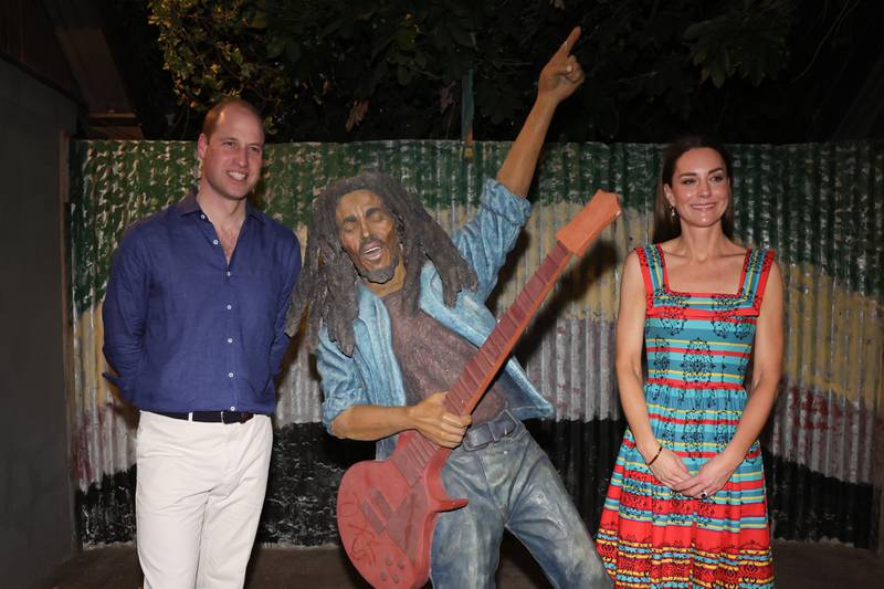 Prince William and Kate pose with a statue of Bob Marley during a visit to the Trench Town Culture Yard Museum. PA