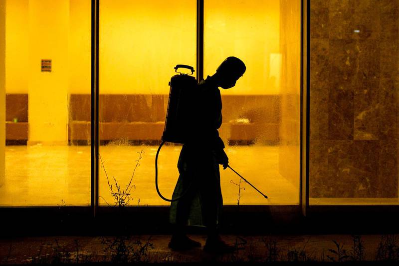 A medical staffer wearing PPE sterilises  the entrance of an isolated section for the coronavirus disease treatment at a hotel in Basra. AFP