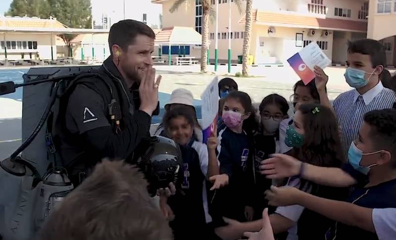 British jetpack aviator Richard Browning hands out invitations for the Museum of the Future to pupils at a school in Dubai.