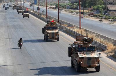 A picture taken shows Turkish military vehicles passing through Maaret Al Numan. AFP
