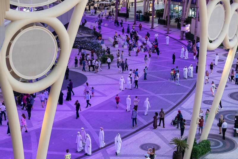 As the sun sets on another day at Expo 2020, visitors enjoy the activities at Al Wasl Plaza. Antonie Robertson / The National