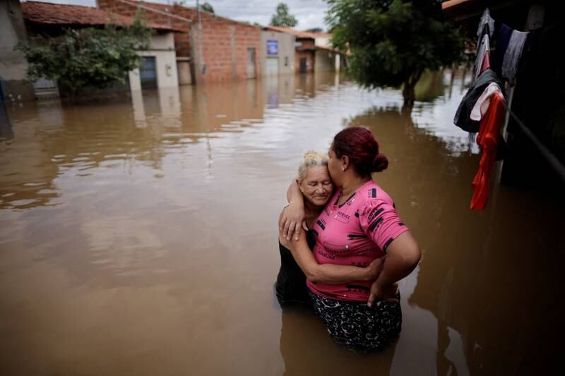 An elderly woman embraces her daughter in front of a flooded house in Imperatriz, Maranhao state, Brazil. Reuters