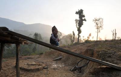 In a picture taken on February 9, 2012, Chandra Bahadur Dangi, a 72-year-old Nepali who claims to be the world's shortest man at 56 centimetres (22 inches) in height, stands near his home in Reemkholi village, Dang district, some 540 kilometres southwest of Kathamandu. Pilloried by neighbours, laughed at in freakshows and spurned by the women he admired from afar, Chandra Bahadur Dangi has always seen his tiny stature as a curse. But the 72-year-old Nepali, who claims to stand at just 56 centimetres (22 inches), is on the brink of life change as significant as a lottery win as experts prepare to test his claim to be the shortest man in history.AFP PHOTO/Prakash MATHEMA
 *** Local Caption ***  864250-01-08.jpg