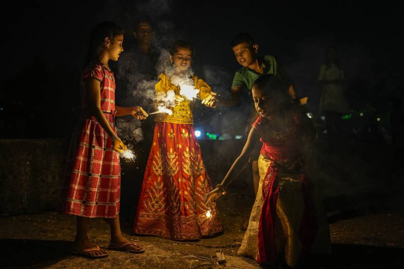 Children light the fireworks in Mumbai. AP