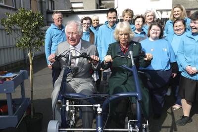 Prince Charles and Camilla test out a bike as they meet volunteers at the Superstars cafe in Cookstown. PA
