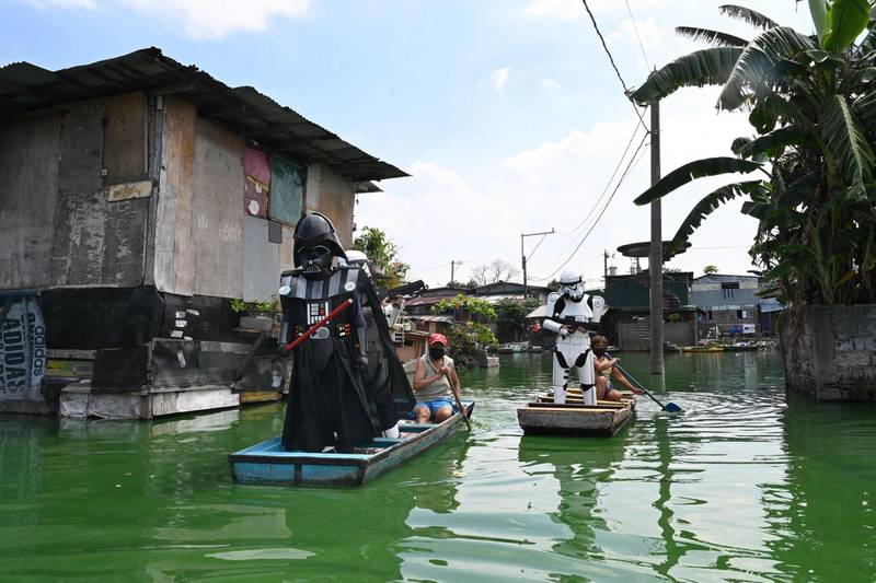 Youths dressed stormtroopers and Darth Vader patrol in wooden boats around a submerged village to remind residents to stay at home during the enhanced community quarantine in suburban Manila. AFP