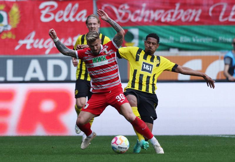 Augsburg's Niklas Dorsch in action with Borussia Dortmund's Sebastien Haller. Reuters