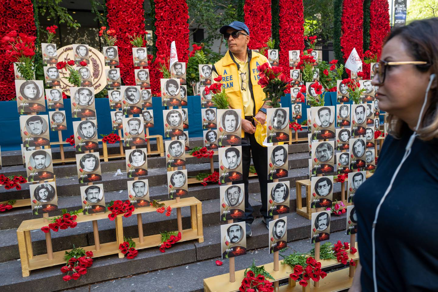 People walk past photos showing the victims of the 1988 massacre of Iranian political prisoners outside of UN headquarters in New York. Getty Images / AFP