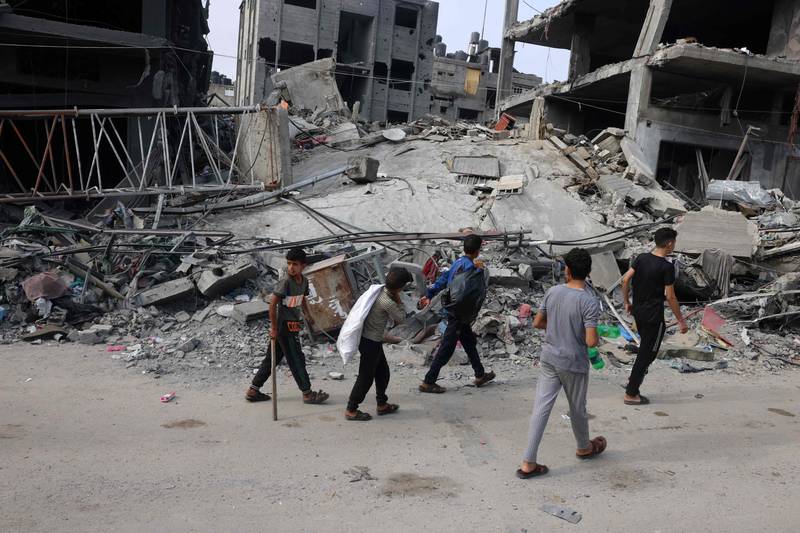 Children walk past a destroyed building in the aftermath of Israeli bombing in Rafah in the southern Gaza Strip on October 28, 2023. AFP