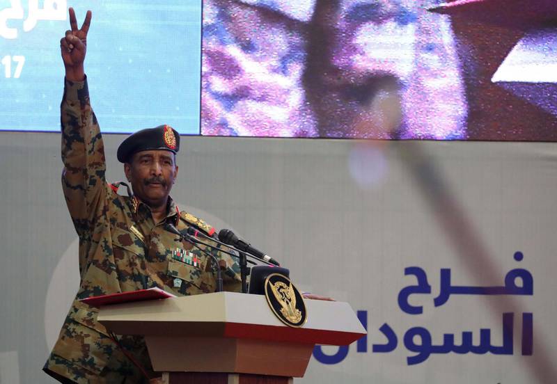 epa07778279 Chairman of Sudan's transitional council, Lieutenant General Abdel Fattah Abdelrahman Burhan flashes a victory sign after addressing the audience, during the ceremony for the signing of the power sharing agreement between the military council an dthe opposition, in Khartoum, Sudan, 17 August 2019. According to reports, Sudan's Military council and opposition signed the power sharing agreement that has been negotiated for many months. The agreement sets up a sovereign council made of five generals and six civilians, to rule the country until general elections. Protests had erupted in Sudan at the end of 2018, culminating in a long sit-in outside the army headquarters which ended with more than one hundred people being killed and others injured. Sudanese President Omar Hassan al-Bashir stepped down on 11 April 2019.  EPA/MORWAN ALI