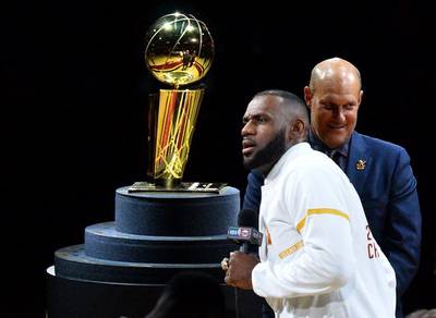 LeBron James of the Cleveland Cavaliers speaks in front of the NBA championship Larry O’Brien Trophy during the pre-game ceremony. Jamie Sabau / Getty Images / AFP