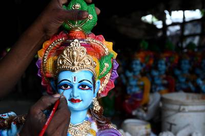 An artisan paints an idol of Krishna in Chennai. AFP