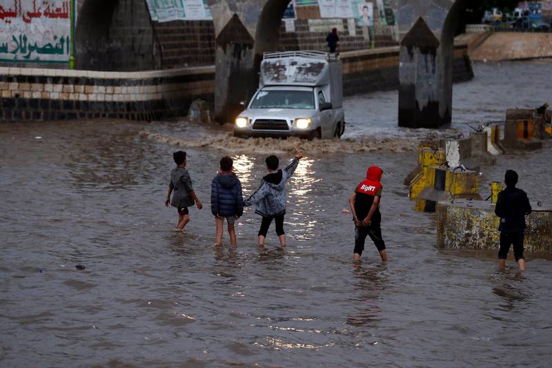 Yemeni children walk through a flooded street following heavy rains in the old quarter of Sana'a, Yemen.  EPA