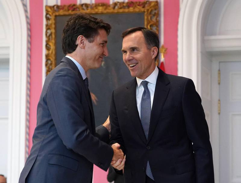 (FILES) In this file photo taken on November 20, 2019, Canadian Prime Minister Justin Trudeau shakes hands with Minister of Finance Bill Morneau during a ceremony at Rideau Hall in Ottawa, Canada minister Bill Morneau announced July 22, 2020, he had repaid more than CAN$41,000 ($30,500) in travel expenses to a charity at the heart of the country's ethics commissioner's investigation into Prime Minister Justin Trudeau. / AFP / Chris Wattie
