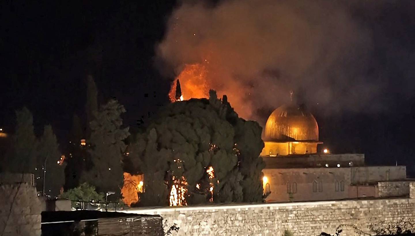 A tree on fire near the Dome of the Rock at Jerusalem's Al Aqsa Mosque compound on May 10, 2021, following renewed clashes between Palestinians and Israeli police at the scene. AFP