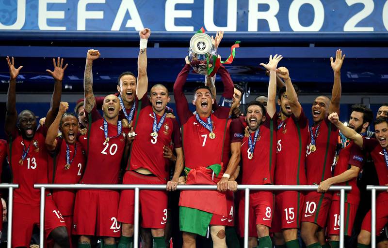 PARIS, FRANCE - JULY 10:  Cristiano Ronaldo of Portugal (c) lifts the Henri Delaunay trophy after his side win 1-0 against France during the UEFA EURO 2016 Final match between Portugal and France at Stade de France on July 10, 2016 in Paris, France.  (Photo by Matthias Hangst/Getty Images)