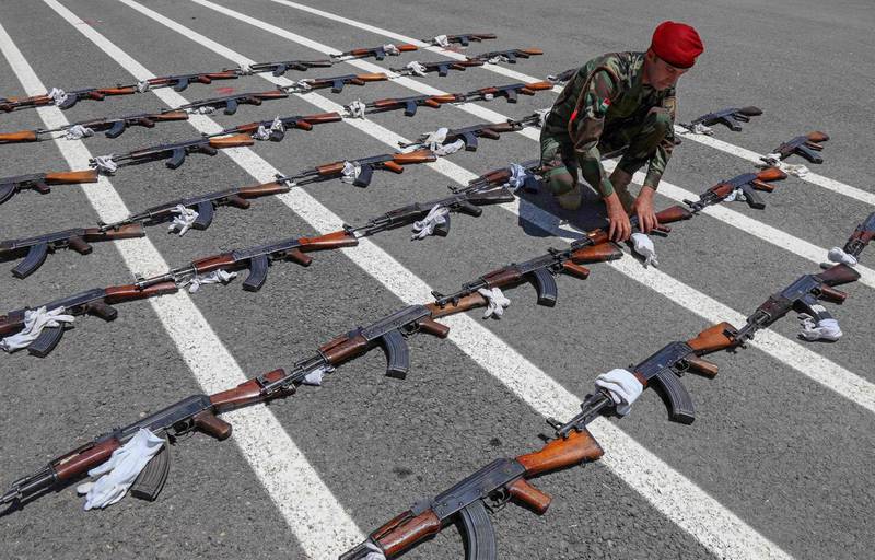 A member of the Peshmerga lays out assault rifles ahead of the officers' passing out parade in Erbil. The force is aiming to replace ageing Soviet-era equipment with Nato weapons. AFP