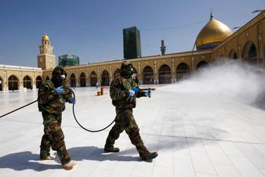 Members of the civil defense team spray disinfectant to sanitize surrounding of the Kufa mosque, following an outbreak of the coronavirus, in the holy city of Najaf, Iraq February 27, 2020. Picture taken February 27, 2020. REUTERS/Alaa al-Marjani