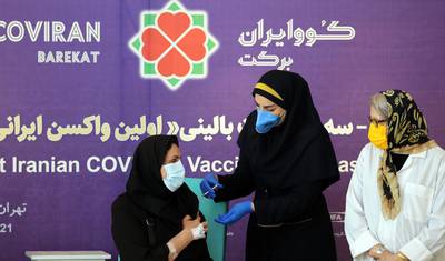 epa09075730 An Iranian health worker injects a dose of locally made COVID-19 vaccine 'COVIRAN Barekat' to Dr. Mehrnaz Rasoulinejad (L) at the beginning of second and third phases of the human test of the vaccine, in Tehran, Iran, 15 March 2021. Phases two and three of clinical trials of the locally-made covid-19 vaccine began on 15 March, after the first phase of human injection took place on 29 December. According to Mohammad Mokhber the head of COVIRAN Barekat vaccine department, the vaccine will be ready in summer for massive vaccination in Iran.  EPA-EFE/ABEDIN TAHERKENAREH