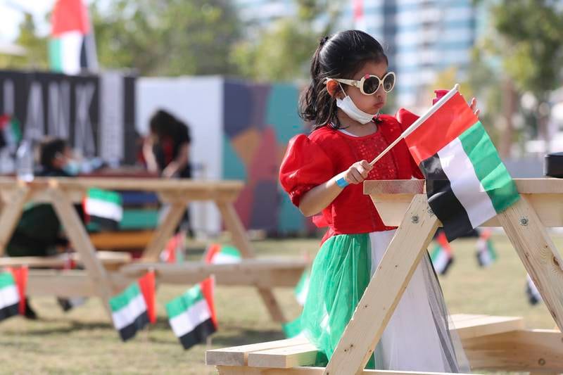 A young girl dressed in the national colours embraces the spirit of the 50th National Day at the Corniche, Abu Dhabi. Khushnum Bhandari / The National