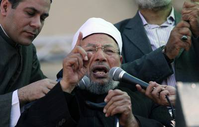 The Doha-based Youssef Al Qaradawi speaks to the crowd as he leads Friday prayers in Tahrir Square in Cairo, Egypt in February, 2011. The outspoken pro-Muslim Brotherhood imam has been critical of the UAE’s policies toward Islamist groups, adding to friction between Qatar and other GCC states. Khalil Hamra / AP Photo

