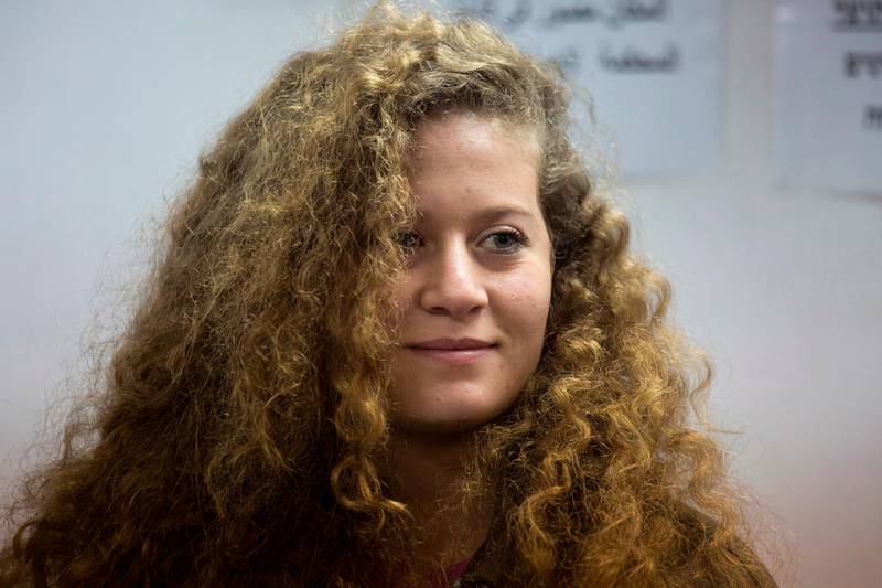 FILE - In this Feb. 13, 2018 file photo, Palestinian Ahed Tamimi stands inside the Ofer military prison near Jerusalem. The family of Palestinian protest icon Ahed Tamimi released a video during a press conference Monday, April 9, 2018, in which two male Israeli interrogators are seen threatening the then-16-year-old and commenting on her body, fair skin and "eyes of an angel." (AP Photo/Ariel Schalit, File)