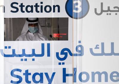 A medical worker in a booth prepares to swab residents at a drive-through test centre in the Dubai suburb of Khawaneej. AFP