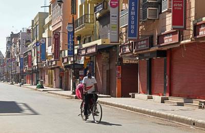 A man rides a bicycle through a deserted market area in the northern Indian city of Amritsar amid the lockdown imposed to prevent the spread of Covid-19. AFP