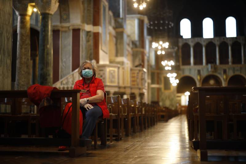 A single worshipper wearing a surgical mask sits on a pew in Westminster Cathedral in central London.  AFP