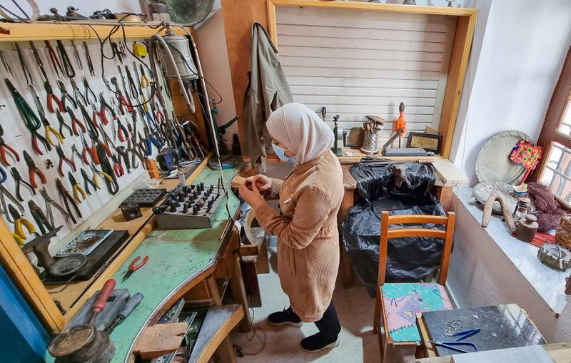 A Libyan woman crafts traditional filigree jewellery at a workshop in the capital Tripoli. Beads and threads of precious materials are woven into intricate designs, then soldered together to create jewellery. AFP