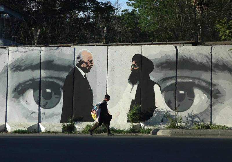 FILE - In this May 5, 2020 file photo, graffiti depicts Washington's peace envoy Zalmay Khalilzad, left, and Mullah Abdul Ghani Baradar, the leader of the Taliban delegation, in Kabul, Afghanistan. After 20 years America is ending its â€œforeverâ€ war in Afghanistan. The U.S. and NATO leave behind an Afghanistan that is at least half run directly or indirectly by the Taliban. (AP Photo/Rahmat Gul, File)