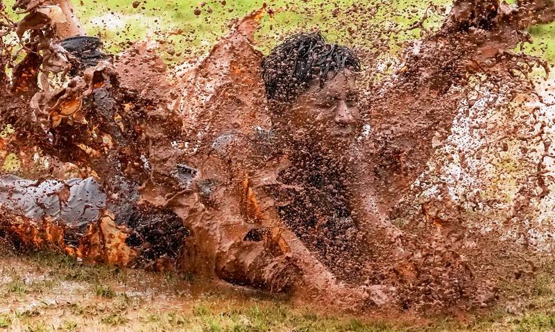 A boy dives through a puddle of muddy water as he enjoys monsoon rain in Mumbai, India. AP