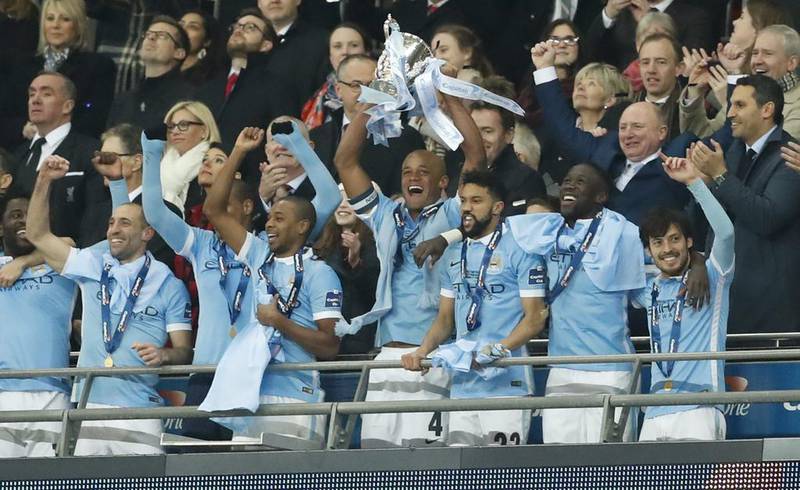 Manchester City’s Vincent Kompany celebrates winning the Capital One Cup Final with the trophy and teammates. Action Images via Reuters / John Sibley