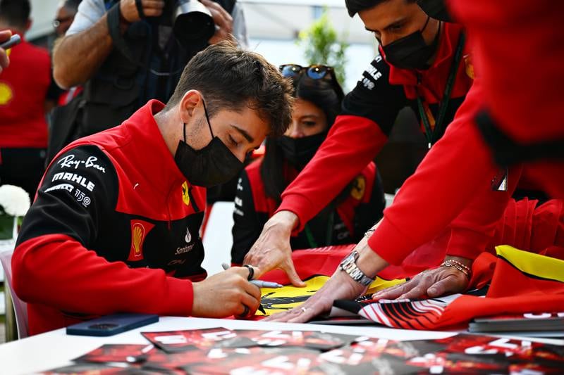 Charles Leclerc signs autographs for fans in the paddock during previews ahead of the F1 Grand Prix of Australia. Getty