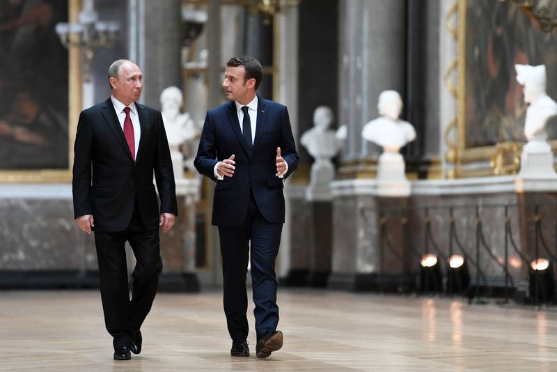 (FILES) In this file photo taken on May 29, 2017, French President Emmanuel Macron (R) speaks to Russian President Vladimir Putin (L) in the Galerie des Batailles (Gallery of Battles) as they arrive for a joint press conference following their meeting at the Versailles Palace, near Paris.  / AFP / POOL / STEPHANE DE SAKUTIN
