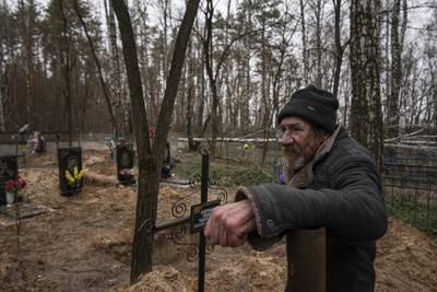Vasyl Cherepenko stands next to a mass grave at a cemetery in Yahidne, near Dnipro, Ukraine. AP