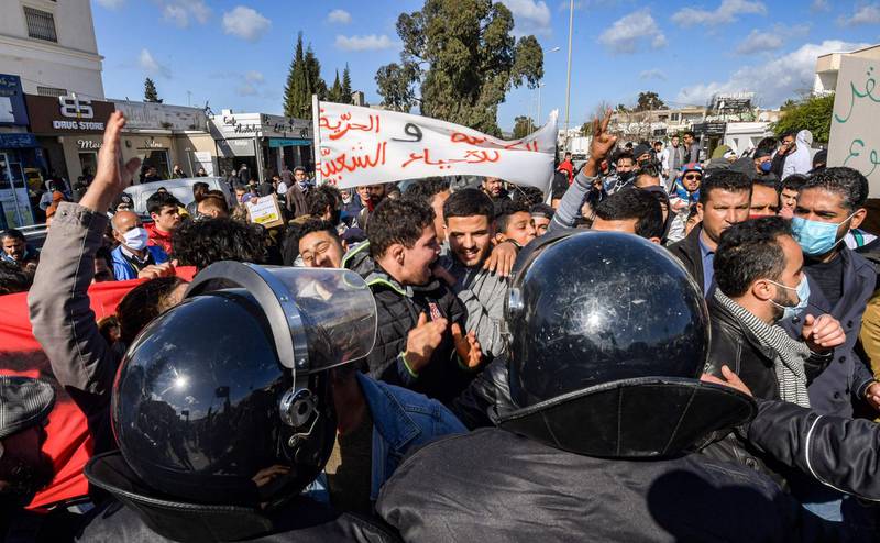 Security forces confront protesters from the Ettadhamen city suburb on the northwestwern outskirts of Tunisia's capital Tunis as they prevent them from passage onwards to reach an anti-government demonstration outside the Tunisian Assembly headquarters.  AFP