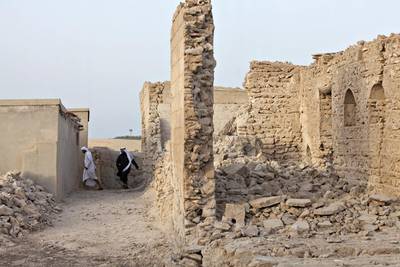 Emirati men walk through some of the ruined homes of Jazirat Al Hamra during the first reunion party in the village in 2012. This year’s celebrations will coincide with National Day. Jeff Topping / The National