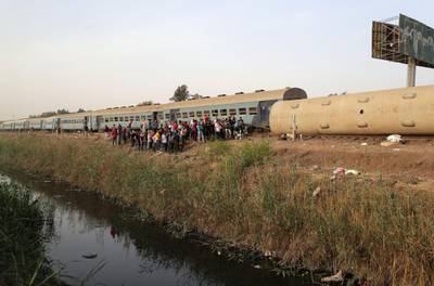People gather at the site where train carriages derailed in Qalioubia province, north of Cairo, Egypt. Reuters