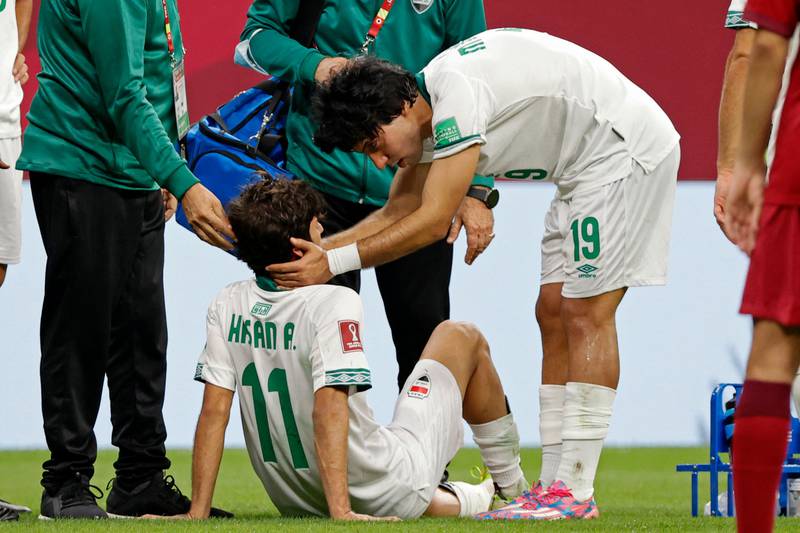 Iraq forward Hasan Abdulkarim receives medical attention after a collision during the Group A match between Qatar and Iraq.