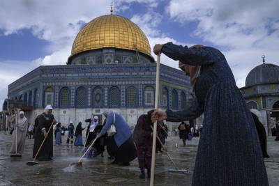Palestinian volunteers clean the ground outside the Dome of Rock mosque at Al Aqsa Mosque compound in Jerusalem's Old City on Saturday. AP