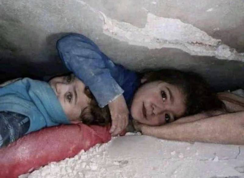 This image of Jinan Sari protecting her brother as they both lay trapped under the rubble was widely circulated on social media. Photo: @mhdksafa / Twitter
