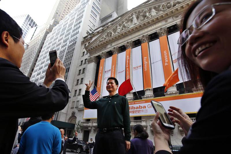 A Chinese tourist poses for a photograph in front of the New York Stock Exchange on the day of Alibaba’s initial public offering. Jason DeCrow / AP Photo